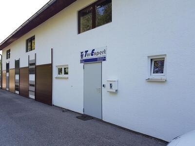 Designbeispiele für Tore und Zäune an einer hellen Hauswand