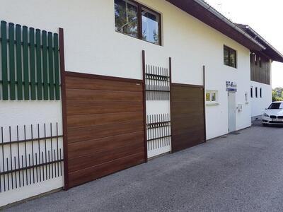 Designbeispiele für Tore und Zäune an einer hellen Hauswand