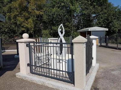 Ausstellung von einer Statue hinter einem Eisen-Gitter-Zaun