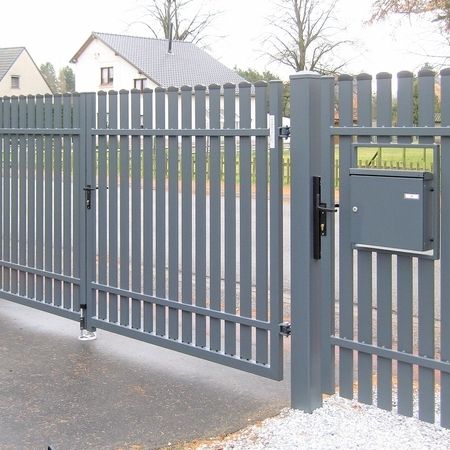 Grauer Zaun vor einer Straße