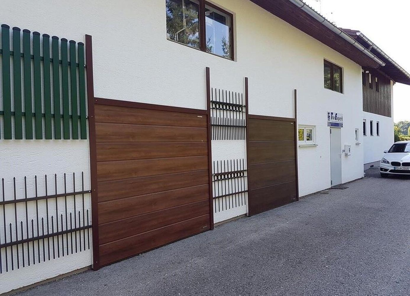 Designbeispiele für Tore und Zäune an einer hellen Hauswand